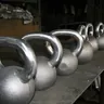Row of steel kettlebells on a workbench (illustrative photo)