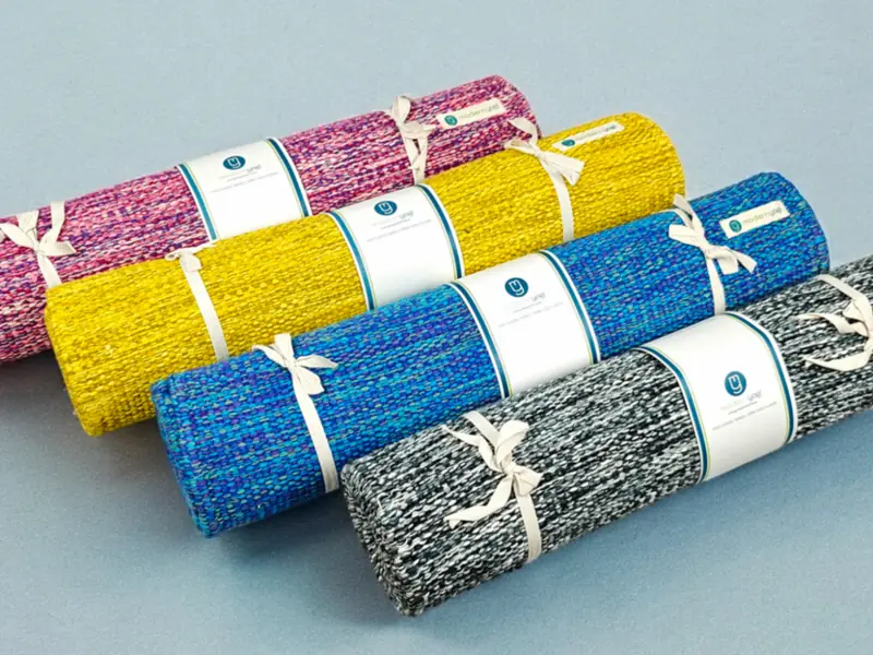 Four rolled yoga mats tied with cord (illustrative photo)