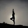 Silhouette of a person in tree pose at dusk (illustrative photo)